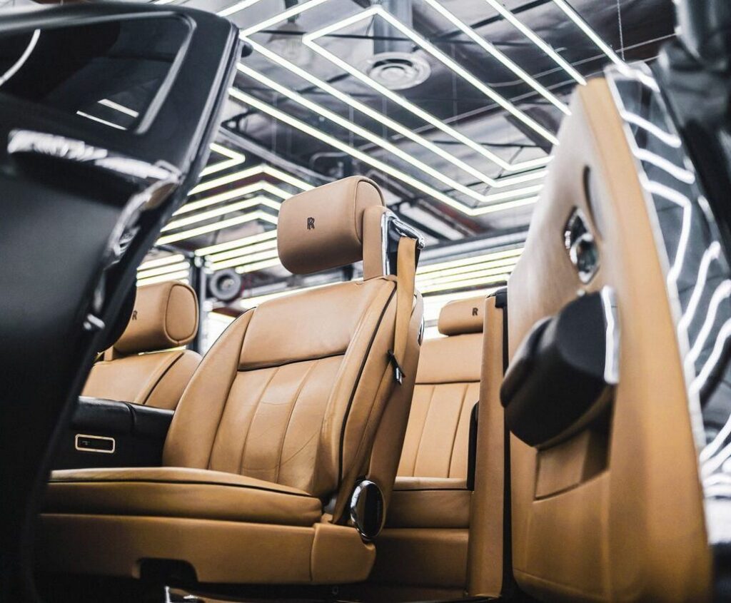 Elegant interior of a luxury car featuring tan leather seats and modern design elements.